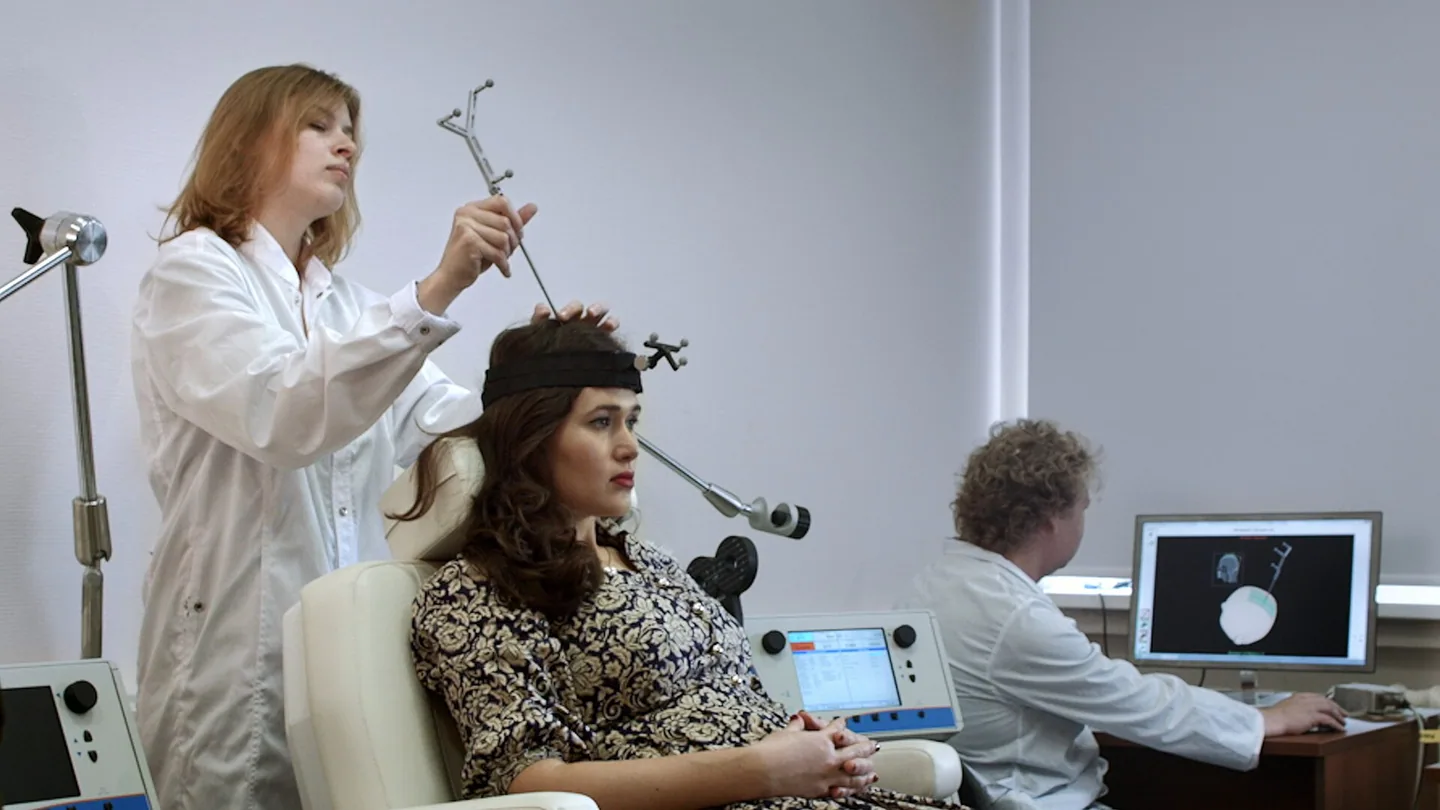 A transcranial magnetic stimulation coil positioned over a participant's head in a neuromodulation laboratory.